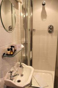 布里格豪斯Bert's Rooms at The Black Horse Inn的浴室配有盥洗盆和带镜子的淋浴
