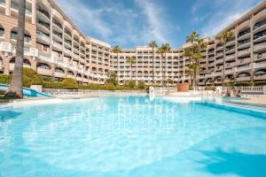 戛纳戛纳海滩皮埃尔假日酒店的大型建筑前的大型游泳池