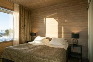 普哈圣山Ski-Inn Kultakero的一间卧室配有一张带两盏灯的床和一扇窗户。