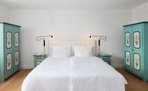 戈尔德格德施霍夫酒店的一间卧室配有一张白色的床和两个蓝色的橱柜。