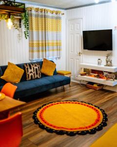 达农Wooden Cosy Retreat Hunters Quay的客厅配有蓝色的沙发和黄色地毯。