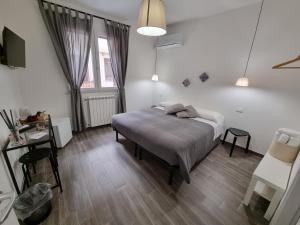 巴勒莫Residenza Tarzanà的一间卧室配有一张床、一张桌子和一个窗户。
