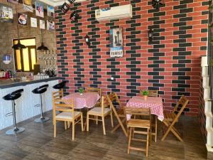 塞拉莱Alnoor Mirbat的一间带桌椅的餐厅以及砖墙