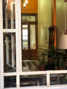 布宜诺斯艾利斯Derby Home Hotel的一座种植盆栽植物的建筑的前门