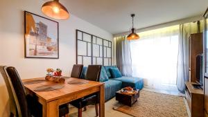 罗兹Apartment Przyfabryczny Księży Młyn - Garaż - Klimatyzacja - FV的客厅配有桌子和蓝色沙发