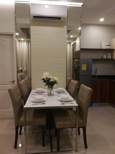 马尼拉Adria Residences - Sapphire Garden - 2 Bedroom for 4 person的餐桌、椅子和花瓶