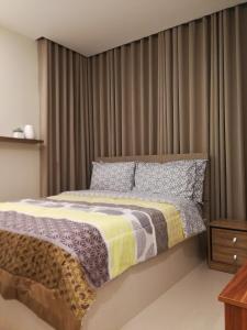 马尼拉Adria Residences - Sapphire Garden - 2 Bedroom for 4 person的一间卧室配有一张带窗帘的大床