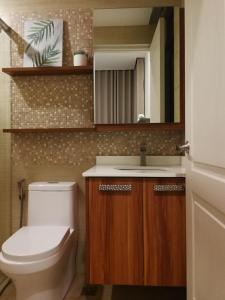 马尼拉Adria Residences - Sapphire Garden - 2 Bedroom for 4 person的一间带卫生间、水槽和镜子的浴室