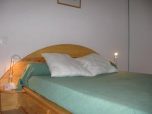 布科·莱斯白老城Appartement Vieux-Boucau-les-Bains, 3 pièces, 6 personnes - FR-1-379-75的一张带木制床头板和两个枕头的床