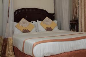 布琼布拉甜蜜生活度假酒店的卧室配有一张带白色床单和枕头的大床。