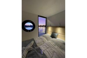 巴特Hausboot Fjord HAVEN mit Biosauna in Barth的一间卧室配有一张大床和镜子