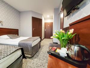 克拉科夫Hotel Fero Express POKOJE KLIMATYZOWANE AC的配有床和鲜花桌的酒店客房
