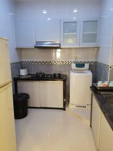 亚依淡Seri Sayang 2 Apartment suite with 2bedroom的小厨房配有白色橱柜和水槽