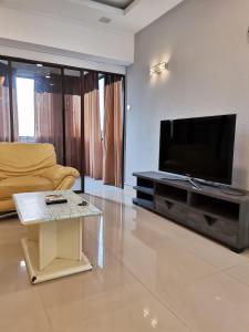 亚依淡Seri Sayang 2 Apartment suite with 2bedroom的客厅配有电视、沙发和桌子