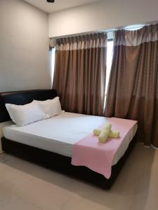 亚依淡Seri Sayang 2 Apartment suite with 2bedroom的一间卧室配有一张床铺,床上铺有粉色毯子