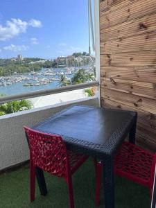 哥西尔Studio mezzanine vue mer的阳台上配有一张黑桌和两张红色椅子