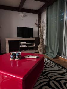 哥西尔Studio mezzanine vue mer的客厅配有红色桌子和电视