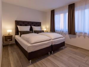 许尔特GLEUEL INN - digital hotel & serviced apartments & boardinghouse mit voll ausgestatteten Küchen的一间带一张大床的卧室,位于带窗户的房间内