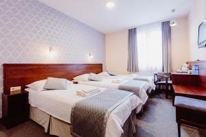 克拉科夫Hotel Fero Express POKOJE KLIMATYZOWANE AC的酒店客房设有三张床和一张书桌