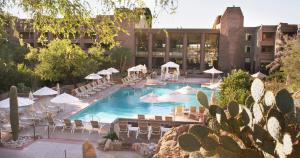 土桑洛伊斯塔纳峡谷度假酒店的一个带椅子和遮阳伞的游泳池和一座建筑