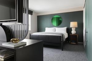 罗斯芒特洛伊斯芝加哥奥黑尔酒店的一间卧室配有一张床和一个绿色镜子