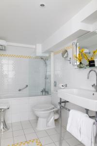 巴黎克里赛酒店的白色的浴室设有卫生间和水槽。
