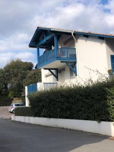 比达尔Bidart côte basque T3 250 mètres de la plage 3***的白色的建筑,上面有蓝色的阳台