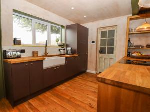 海斯廷斯Oak Meadow的厨房配有黑色橱柜和木地板