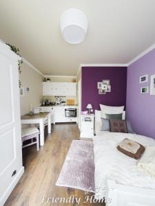 BrenigFriendly Home - Einzelappartement "Calm" Köln Bonn Phantasialand的一间卧室设有紫色的墙壁和一张带桌子的床