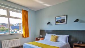 巴利卡斯尔Marine Hotel Ballycastle的一间卧室设有一张床和一个窗口