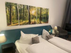 哈嫩克利博克斯维斯Berghotel HARZ的酒店客房设有两张床,墙上挂有两幅画作