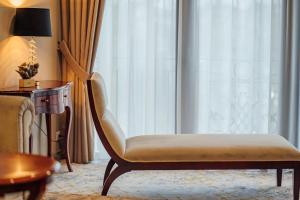卡雷L`Art Hotel Carei的一张位于酒店客房的椅子,设有窗户