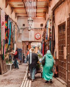 马拉喀什Riad Musa的两个人在小巷里走下一条街道