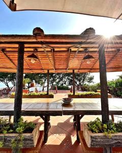 埃尔科拉诺B&B Iolì Vesuvio的天井上配有带木制遮阳伞的野餐桌
