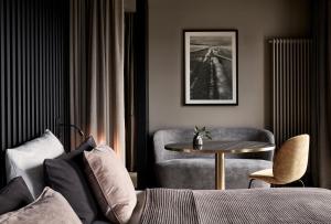 明斯特明斯特曼瑞兹霍夫酒店的带沙发、桌子和椅子的客房