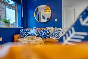 达德利DUDLEY by HOSPITAL - 5 beds - PARKING - Long stay - CONTRACTORS的客厅拥有蓝色的墙壁,配有带枕头的沙发。