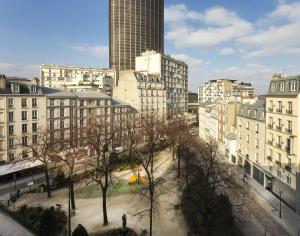 巴黎Hôtel du Parc Montparnasse的一座高楼城市和一个树木繁茂的公园