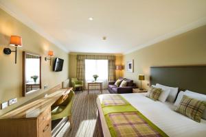 珀斯Leonardo Boutique Huntingtower Perth的酒店客房设有一张大床和一间客厅。