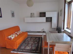 斯特雷萨Appartamento Bilocale Dante的客厅配有橙色沙发和桌子