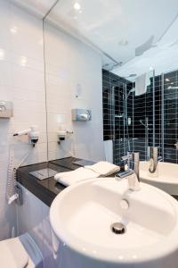 不莱梅不来梅机场快捷假日酒店的白色的浴室设有水槽和镜子