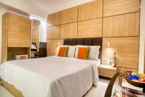加尔各答罗兰德酒店的卧室配有一张白色大床和木墙