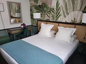 塞纳河畔讷伊巴黎讷伊酒店的卧室配有带白色枕头的大床