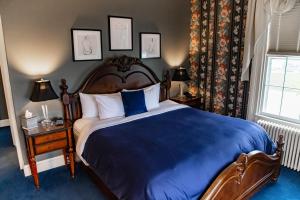 伊萨卡Inn at Taughannock Falls的一间卧室配有一张带蓝色毯子的大床