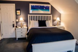 伊萨卡Inn at Taughannock Falls的一间卧室配有一张带2个床头柜和2盏灯的床。
