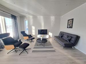 NärpiöALEX - bright, stylish apartment with sauna, built in 2023的客厅配有黑色沙发和椅子