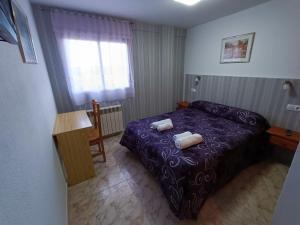 塞哥维亚塔拉伊君悦旅馆的一间卧室配有一张紫色床和两条毛巾