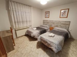 塞哥维亚塔拉伊君悦旅馆的一间卧室设有两张床和窗户。