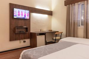 沃尔塔雷东达Dexter Hotel - Volta Redonda的一间酒店客房,设有两张床和电视