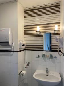 图尔瓦勒德洛尔酒店的白色的浴室设有水槽和镜子