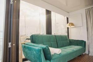 波瓦-迪瓦尔津Floating Experience - Casa flutuante a 25 min do Porto的客厅设有一张绿色沙发,配有窗户
